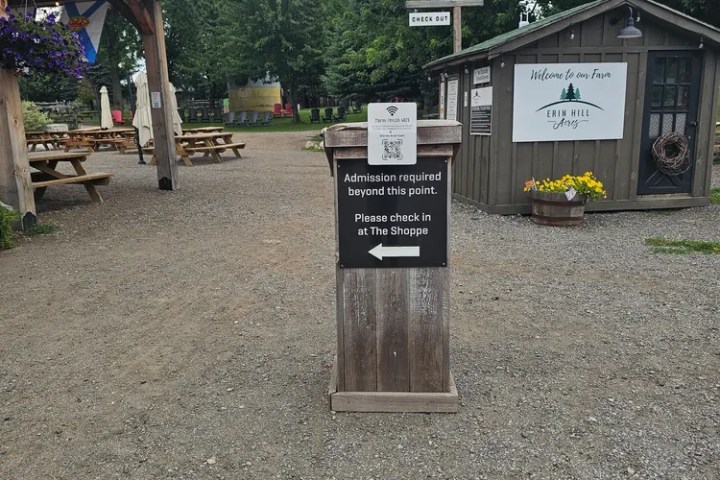 Sign in outdoor area: 'Admission required beyond this point. Please check in at The Shoppe.'