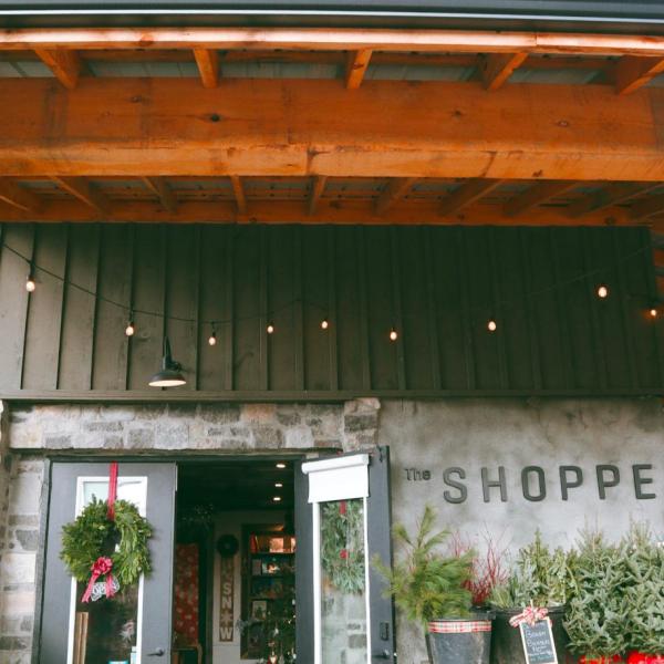 Rustic shop entrance with Christmas decor and wreaths.